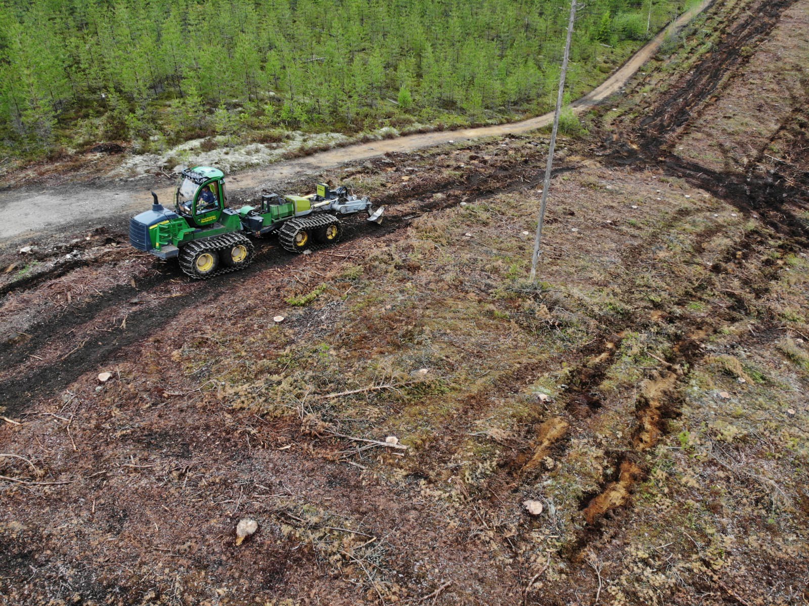 John Deere 1510 ja Bracke-mätästäjä muokkaavat hakkuuaukeaa, ilmakuva